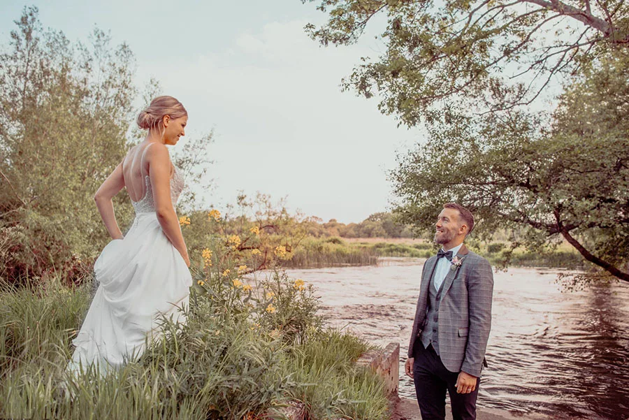 A very natural image of Bride & Groom by the river at Sopley Mill in Christchurch Dorset