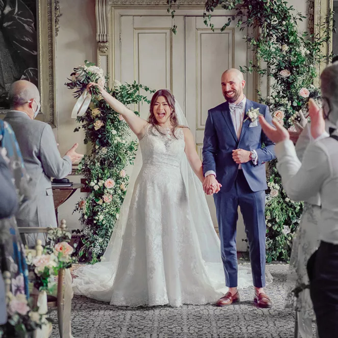 Bride and groom celebrating during the ceremony at St Giles House in Dorset
