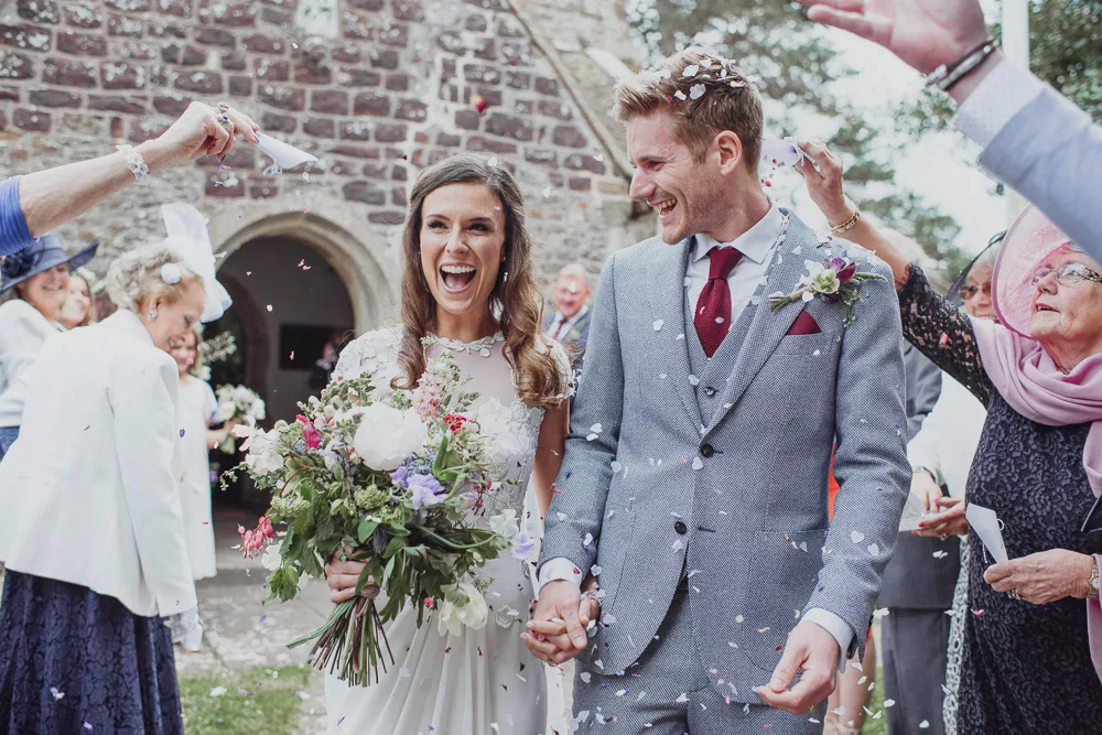 Bride and Groom having fun with confetti a memorable moment at Sopley Mill in Dorset