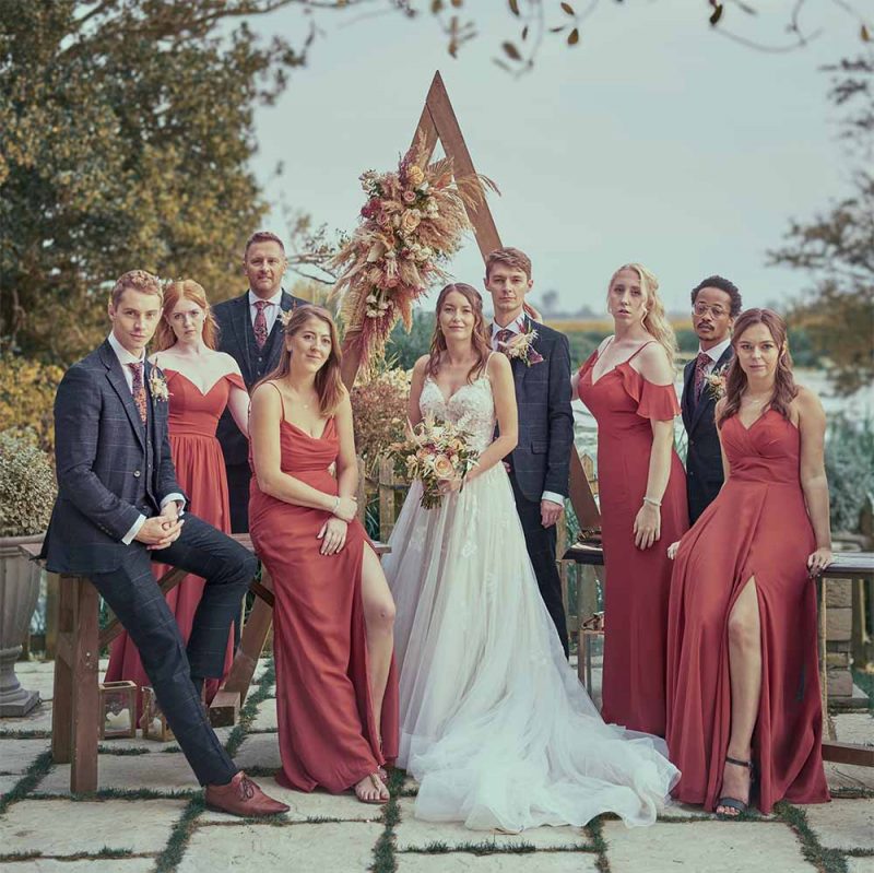A Bride & Groom group picture showing the beautiful location at Sopley Mill wedding venue