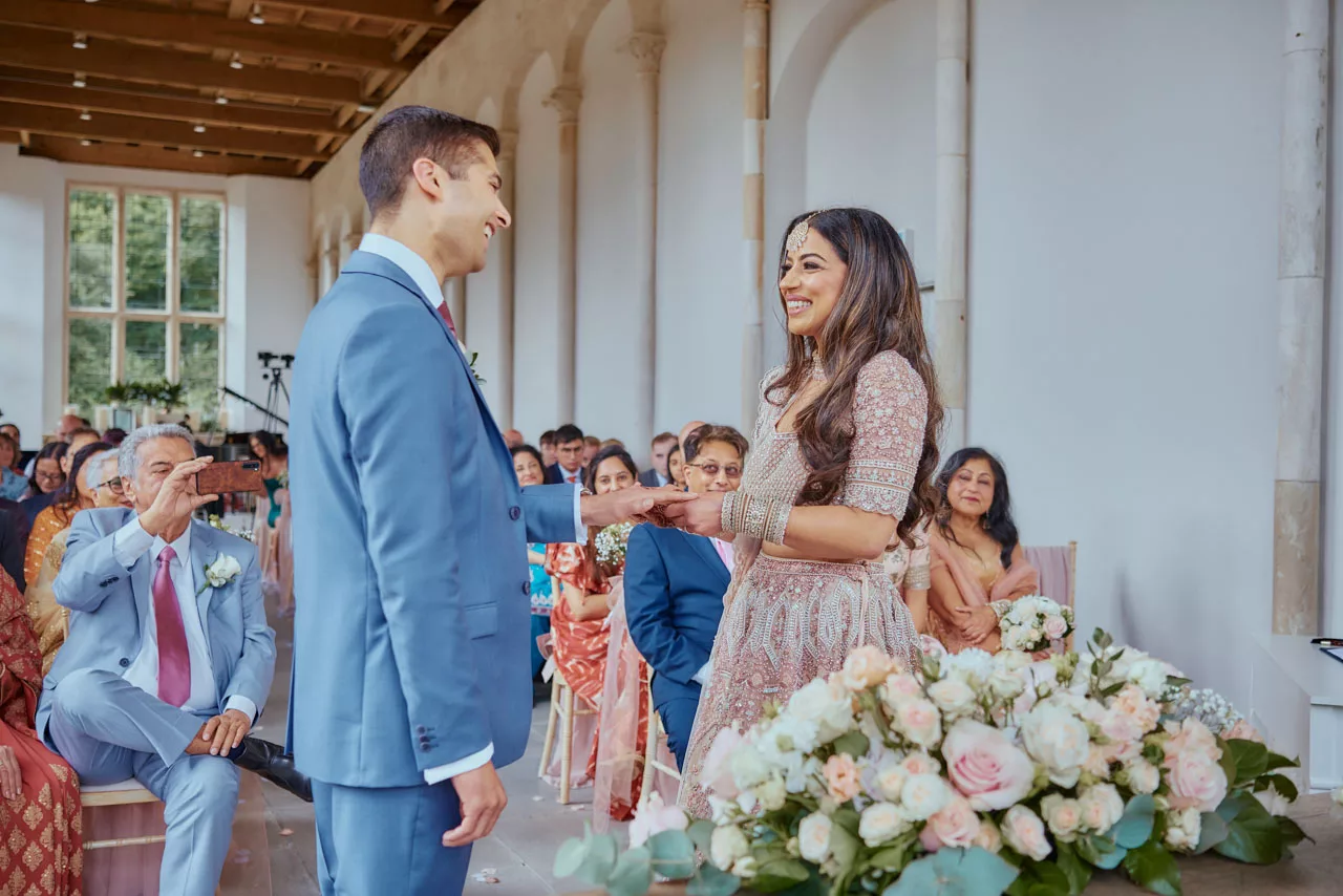 Bride & Groom exchange rings during Indian Fusion Wedding ceremony at Highcliffe Castle in Dorset
