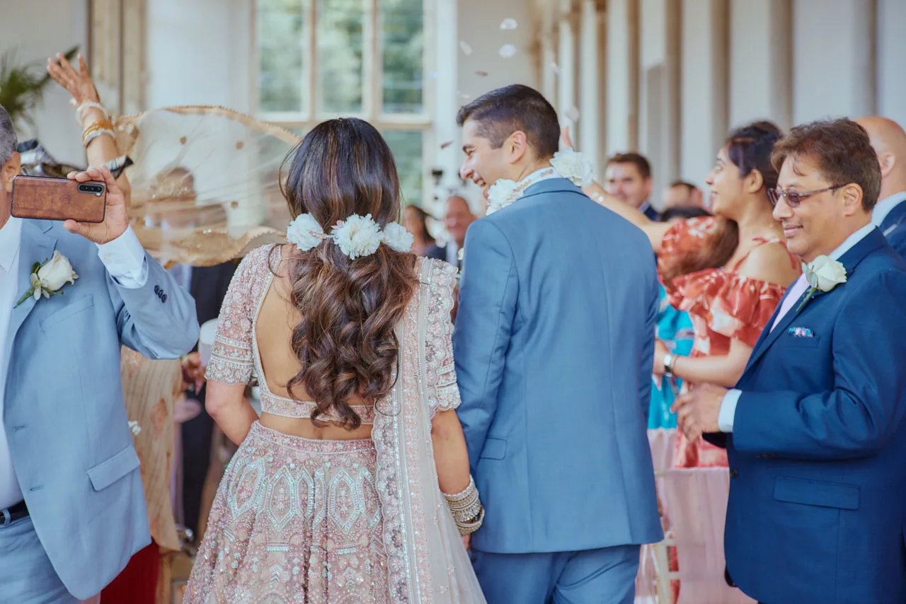 Guests throw confetti down the isle during Indian Fusion Wedding ceremony at Highcliffe Castle in Dorset