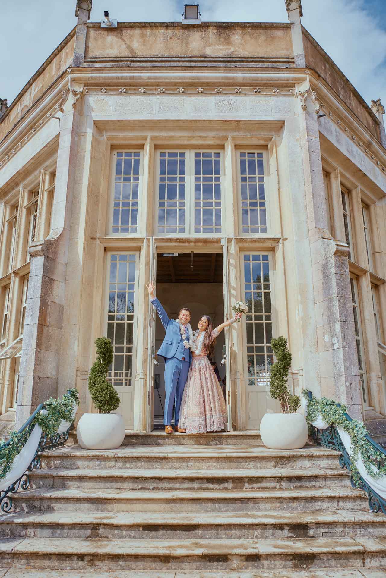 Bride & Groom celebrate on the steps during Indian Fusion Wedding ceremony at Highcliffe Castle in Dorset