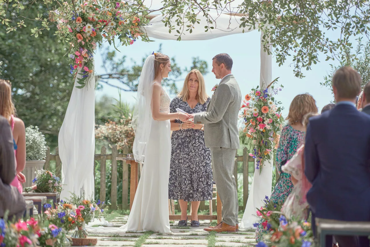 An Amazing light and bright image of Bride and groom exchanging rings during an outdoor wedding ceremony at Sopley Mill