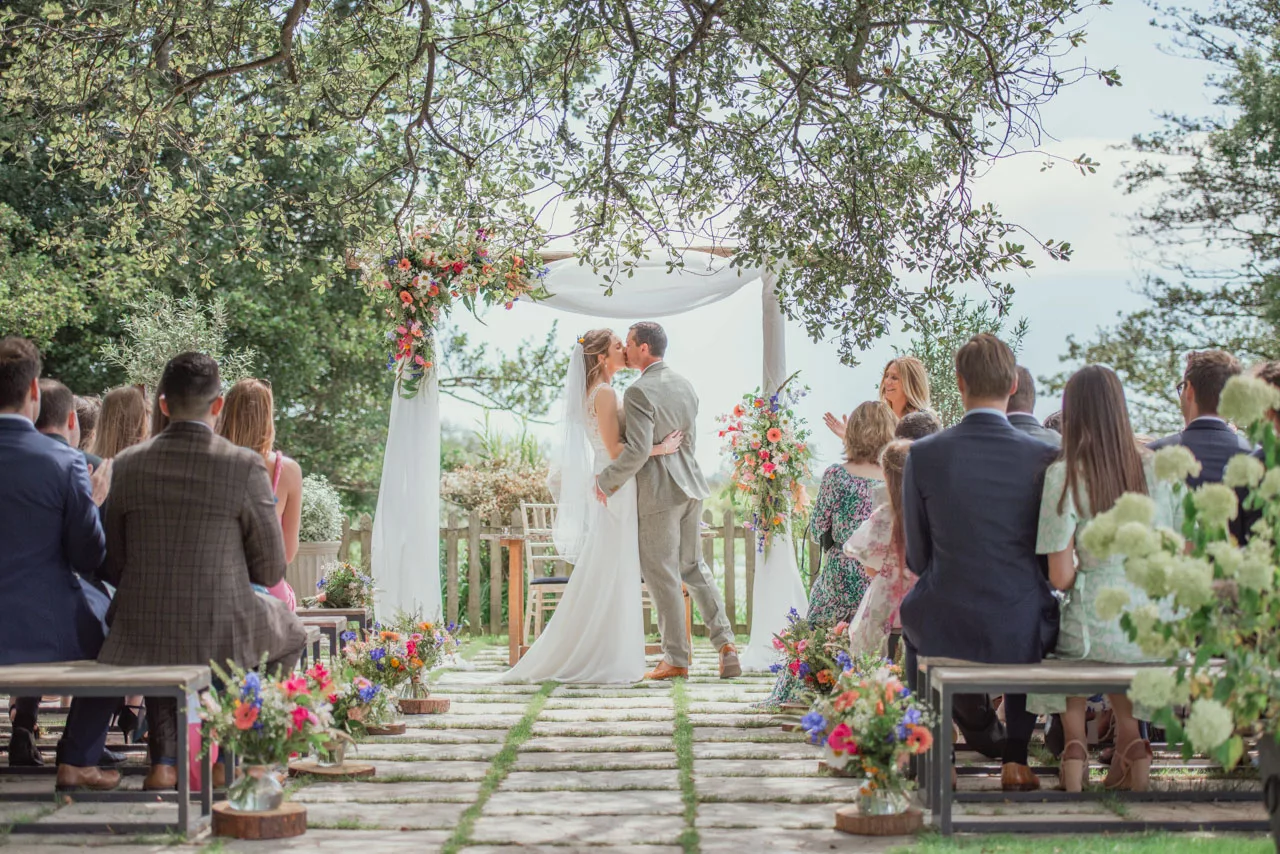 An Amazing natural light and airy bright image of Bride and groom during an outdoor wedding ceremony at Sopley Mill
