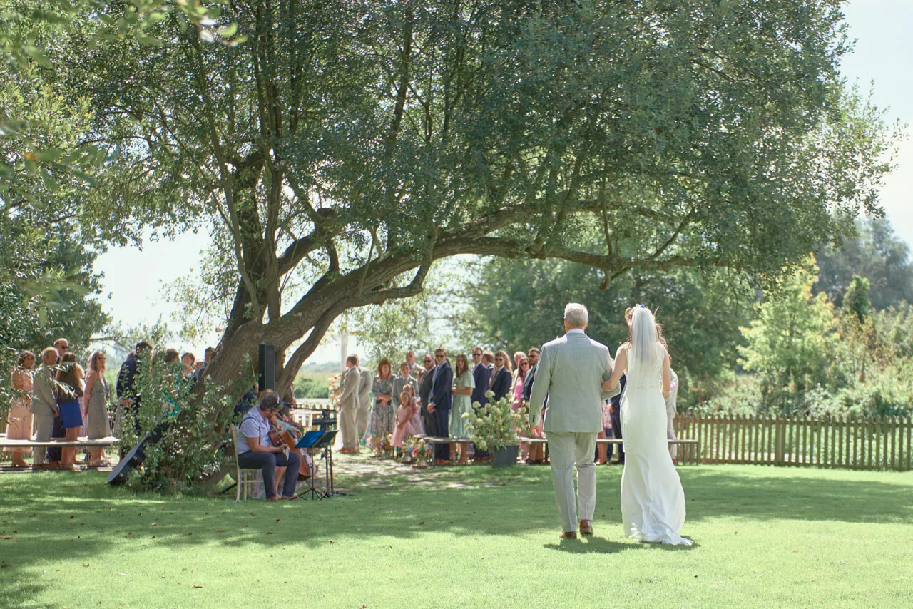 Bride walking to the Ceremony during an outdoor wedding at Sopley Mill