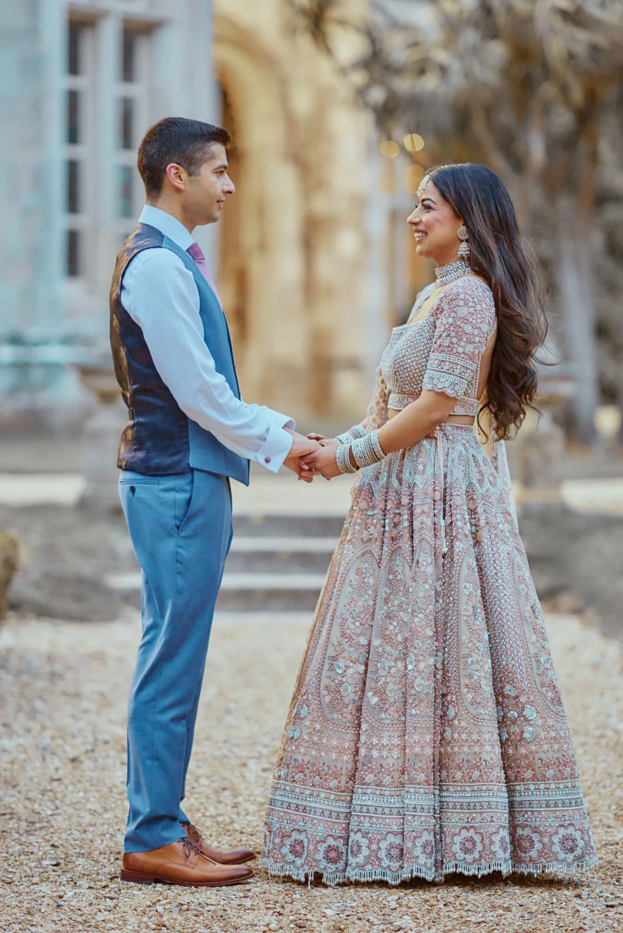 Bride & Groom holding hands in the grounds of Highcliffe Castle in Dorset during  a beautiful Indian Wedding