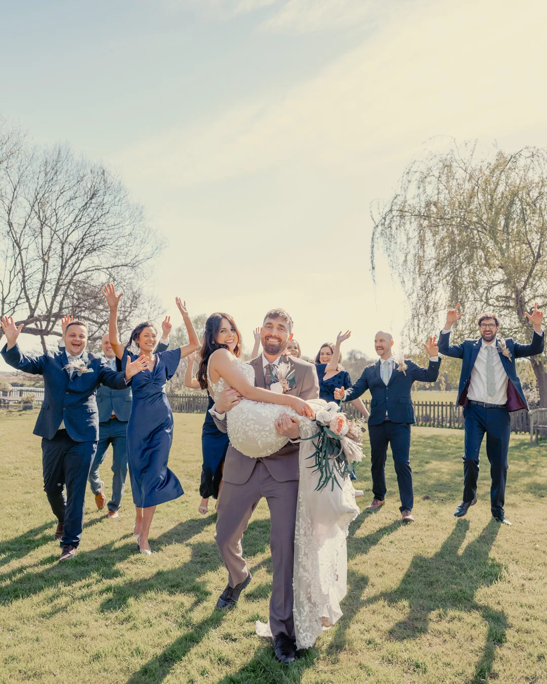 Bride and groom and bridal party having fun in the grounds of Sopley mill during a Spring wedding