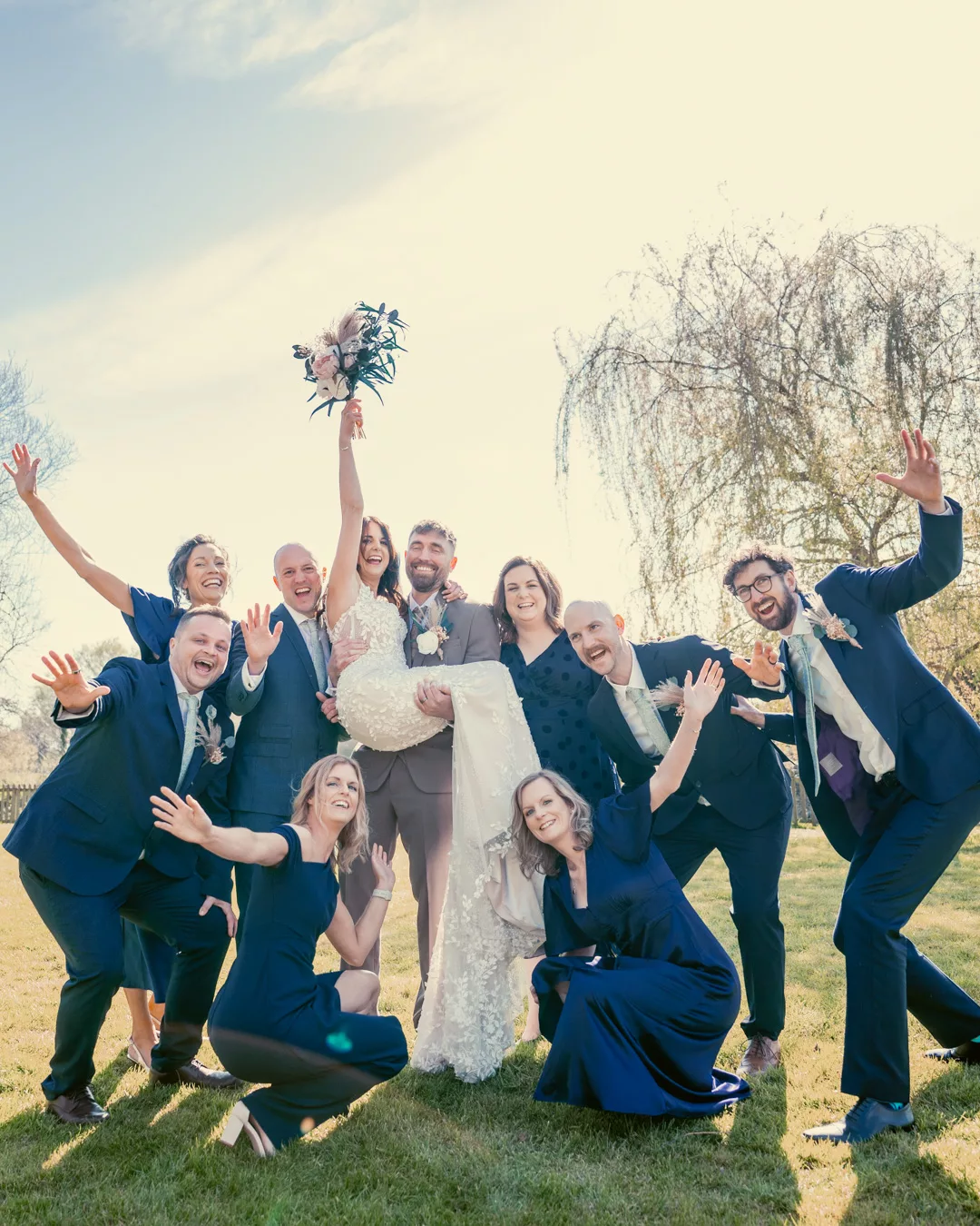 Bride and groom and bridal party having fun in the grounds of Sopley mill during a Spring wedding