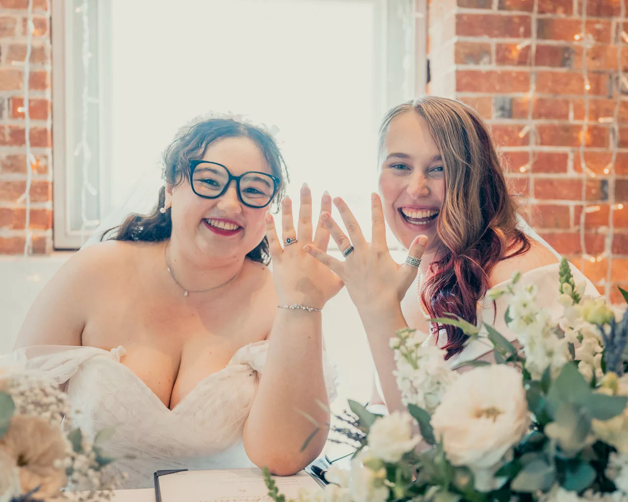 Two Brides show of their wedding rings during their ceremony at Sopley mill