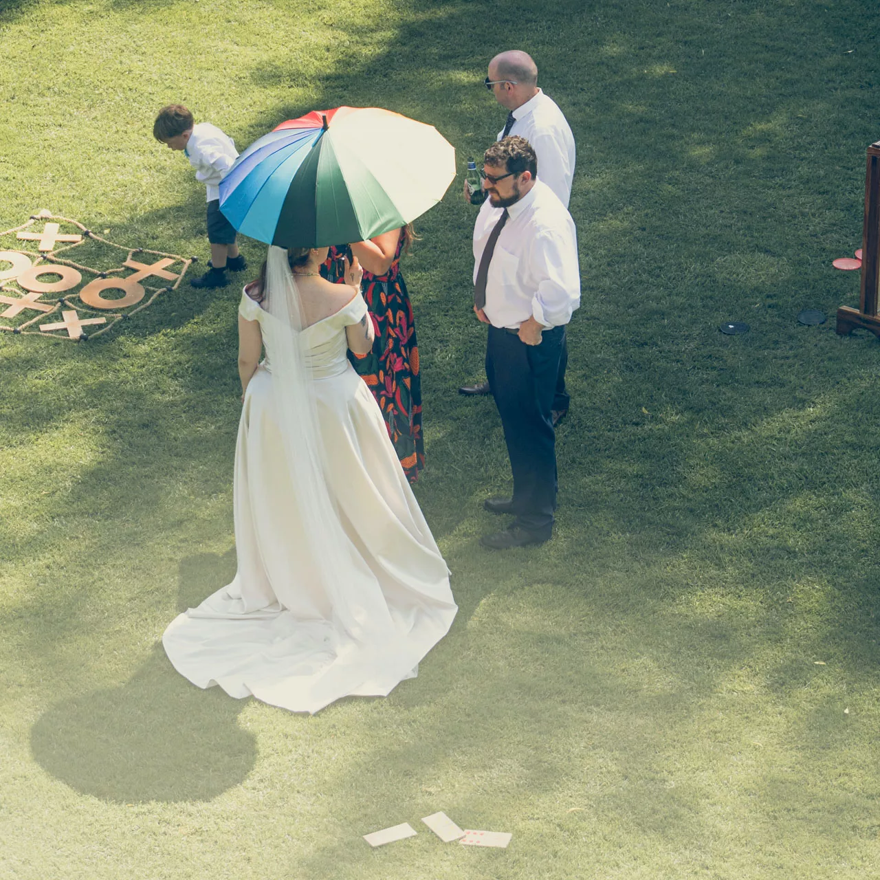Bride with Gay Pride coloured umbrella during wedding at Sopley Mill