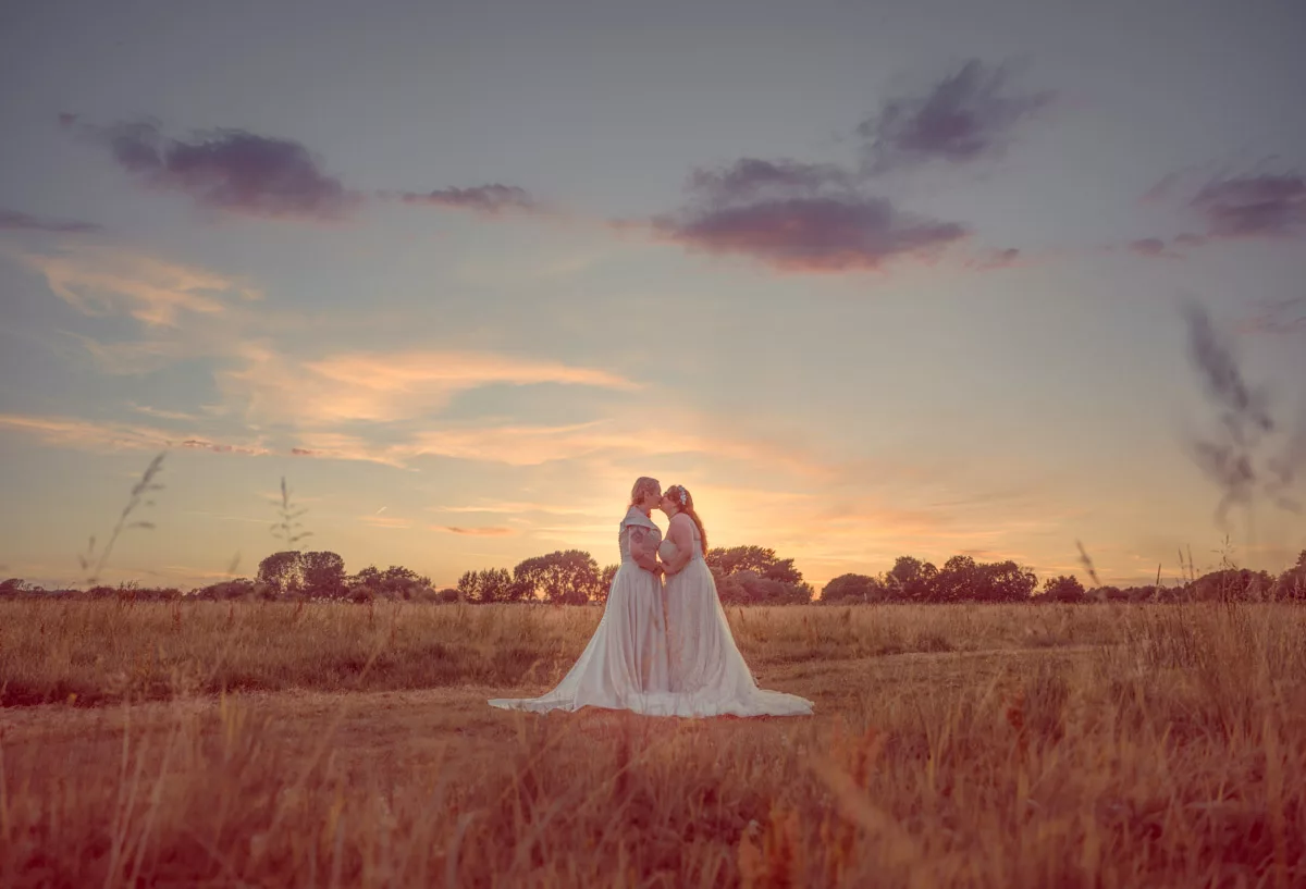 Two Brides in the grounds of Sopley mill after their wedding at sunset 
