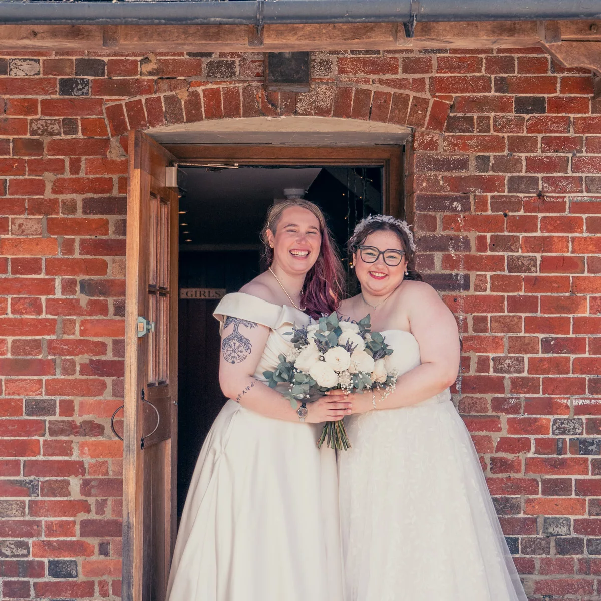 Two Brides in the doorway of Sopley Mill after their wedding. 