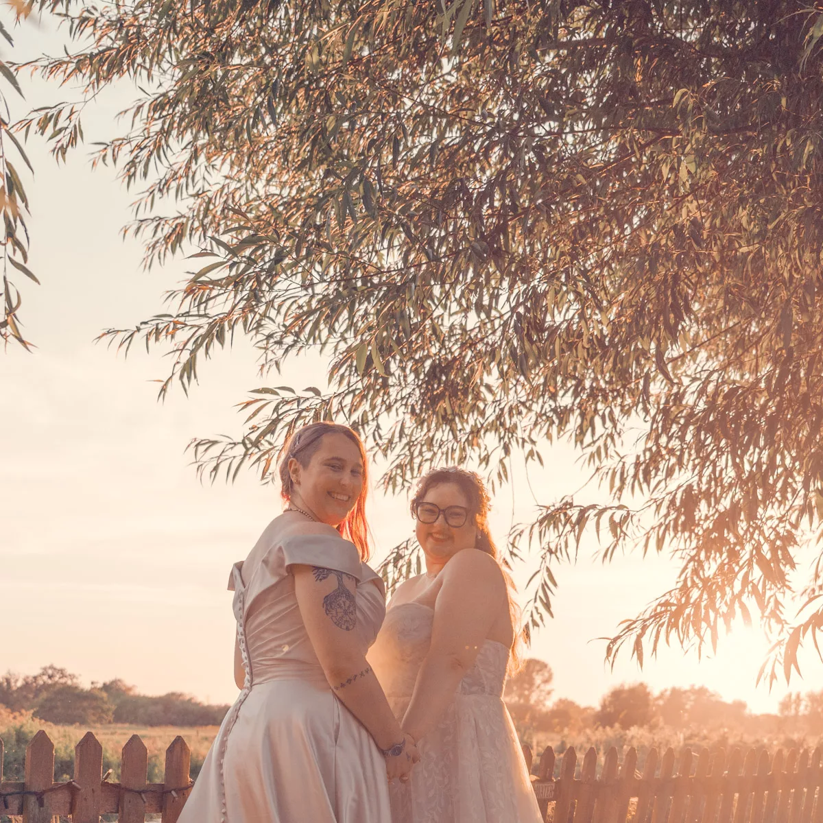 Two Brides in the outside wedding area under the trees at Sopley Mill at sunset